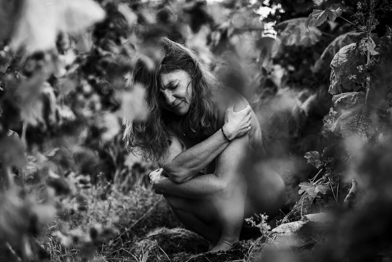 gebückte Frau umarmt Knie, Online-Psychotherapie, Trauma